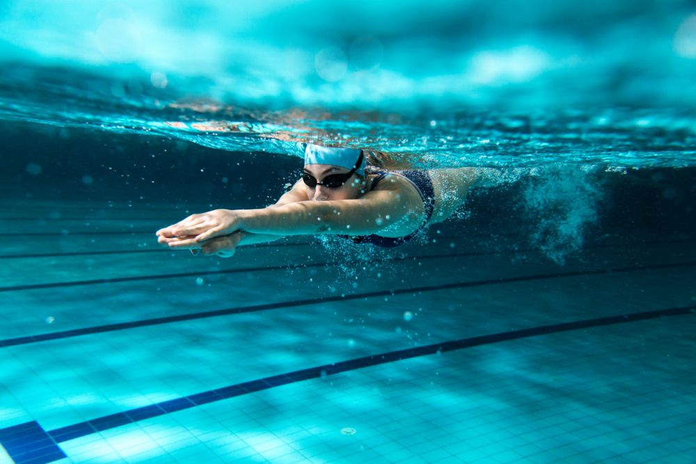 Female swimmer at the swimming pool. Underwater photo