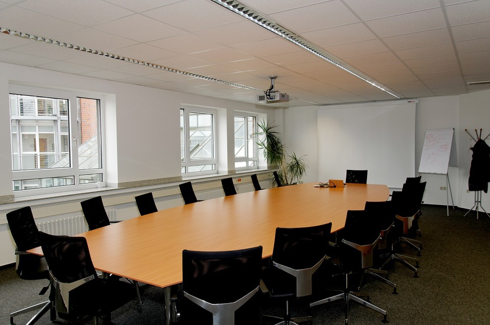 A conference room with black chairs and brown conference desk