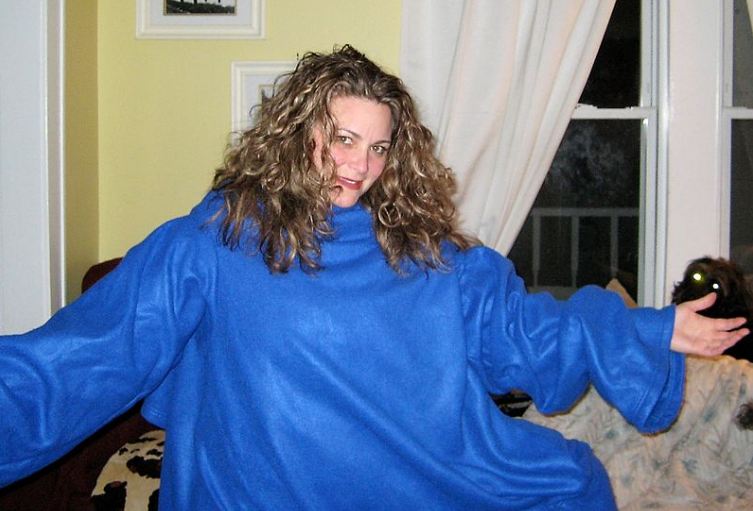 A woman wearing an oversized blue snuggie. Notice that size and fit do matter a lot