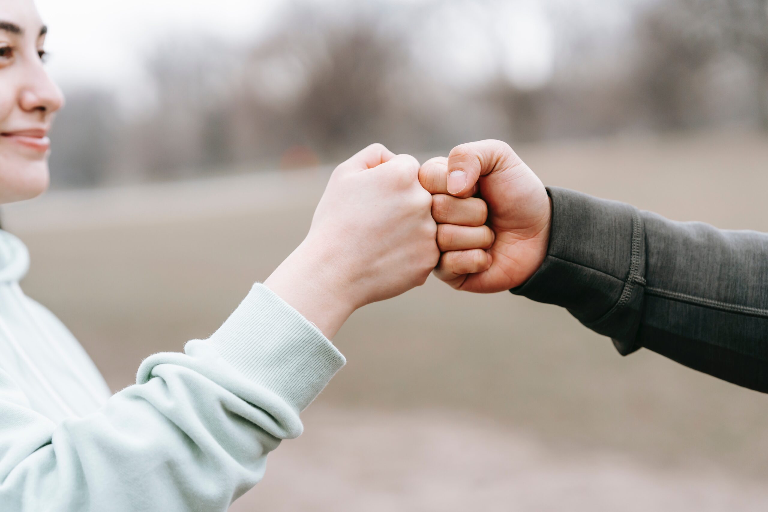 man-and-happy-woman-greeting-each-other-with-fist-bump