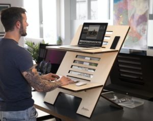 a-man-using-a-foldable-standing-desk-at-work